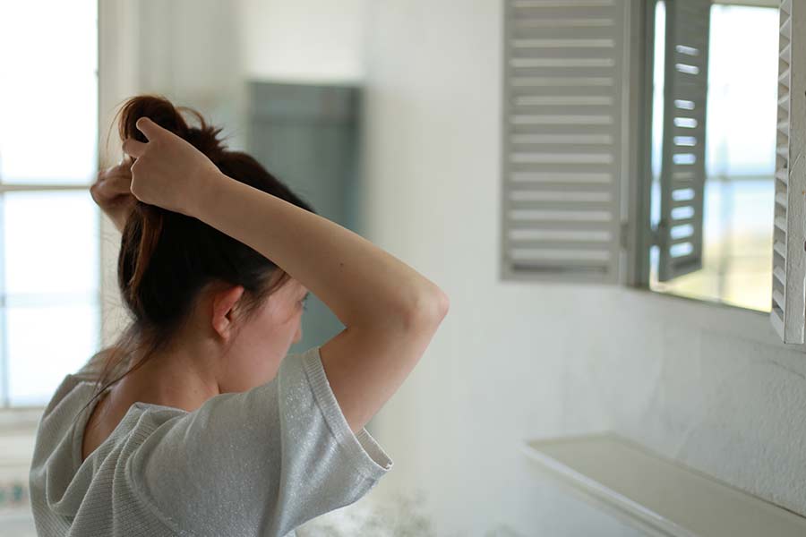 Young woman putting her hair up