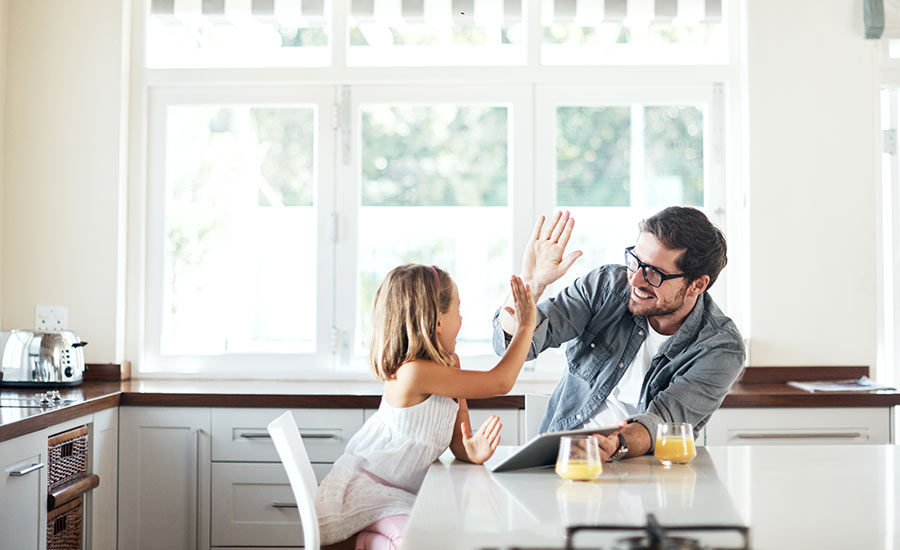 Father and daughter high-fiving at breakfast