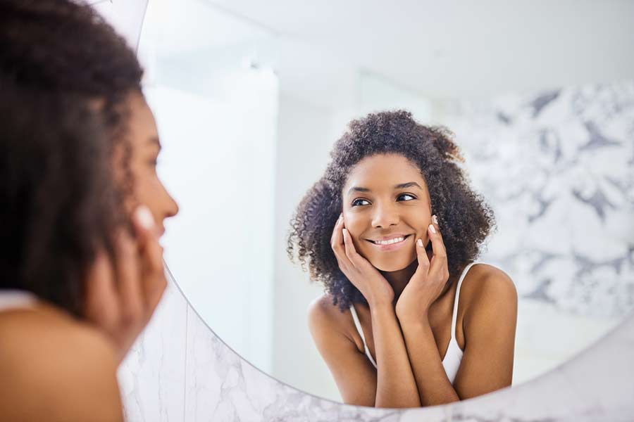 young woman smiling in the mirror