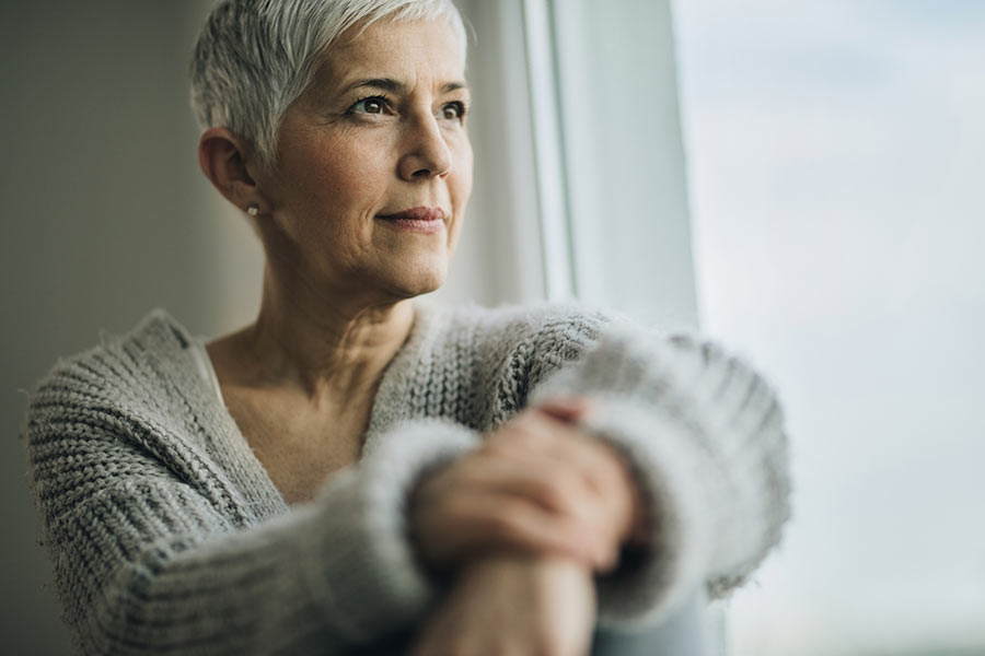 older woman looking out window