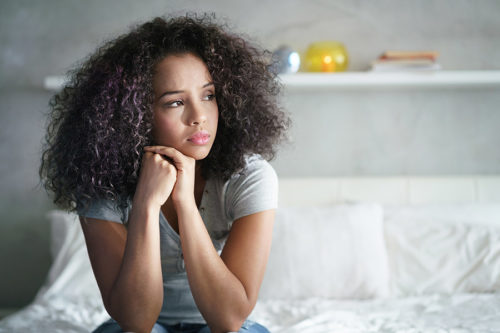 woman on bed looking out a window