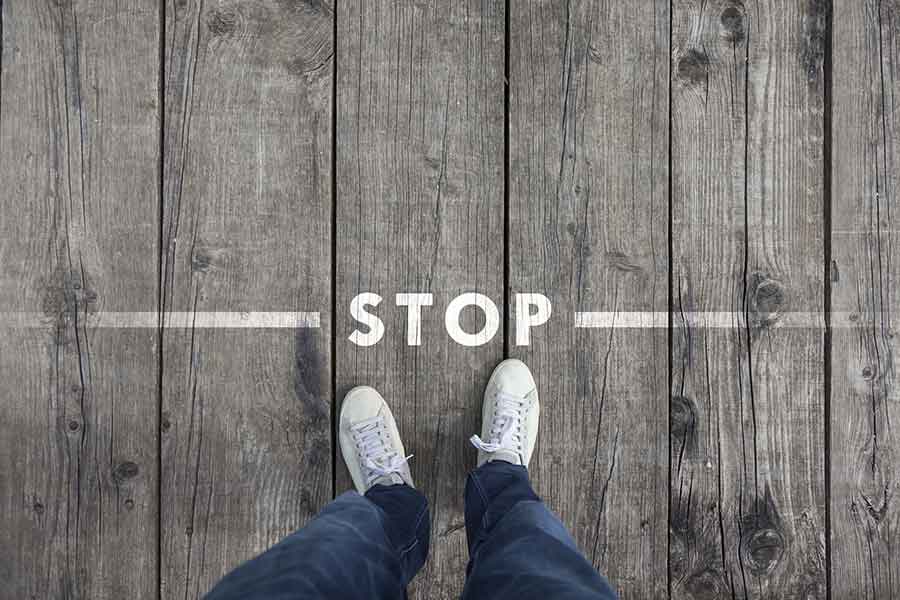 Person standing on a wood floor with stop painted on it