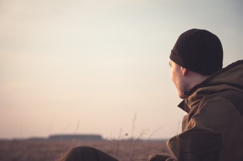 Man looking out over horizon in field