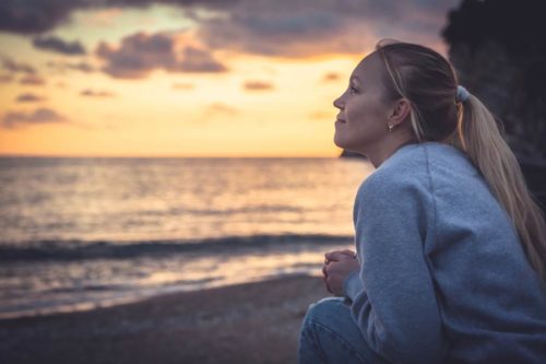Woman relaxing on beach at sunset
