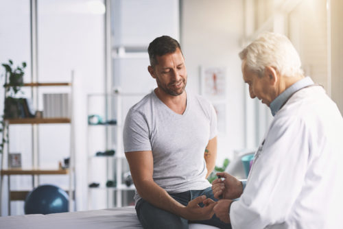 Man consulting with doctor on bed