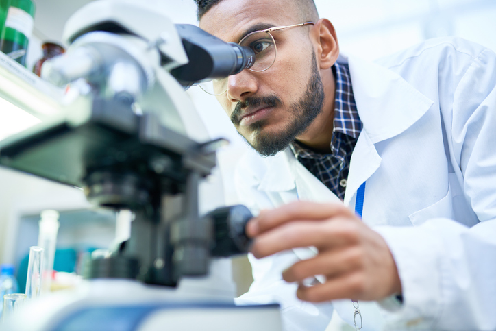 A male scientist using a microscope in a laboratory.