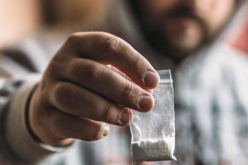 Man holding a bag of powder