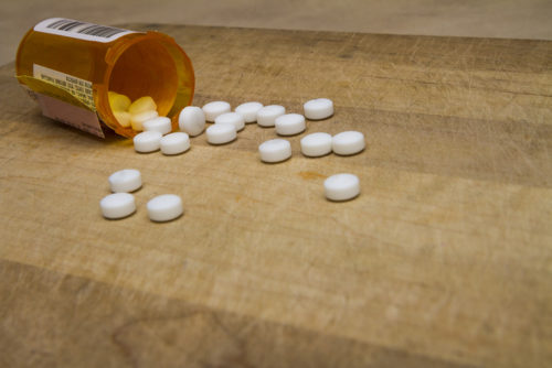 Pill bottle resting on a wooden surface