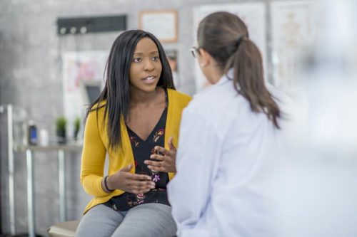 Woman consulting with doctor in hospital