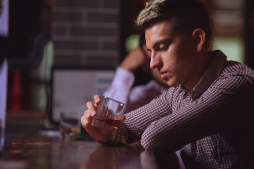 Man enjoying whiskey at bar