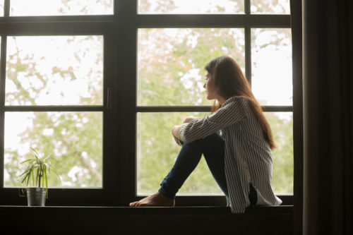 Woman gazing out from window sill