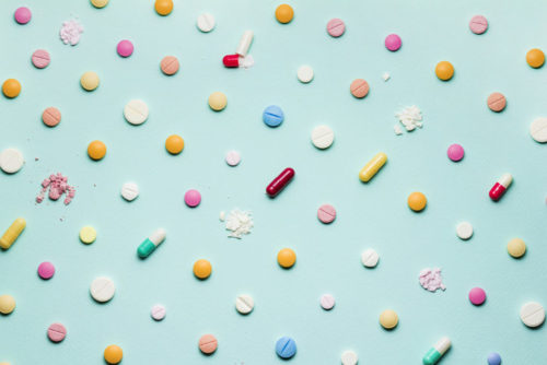 Colorful pills scattered on a blue background