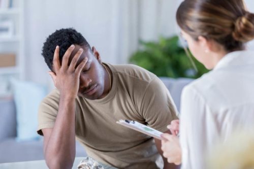 Distressed man on couch, head down