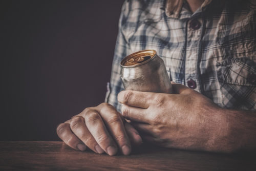 Male hands holding a aluminum can.