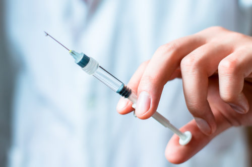 Person holding a syringe ready for injection