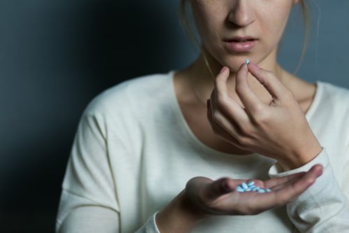 Woman holding pills in her hand