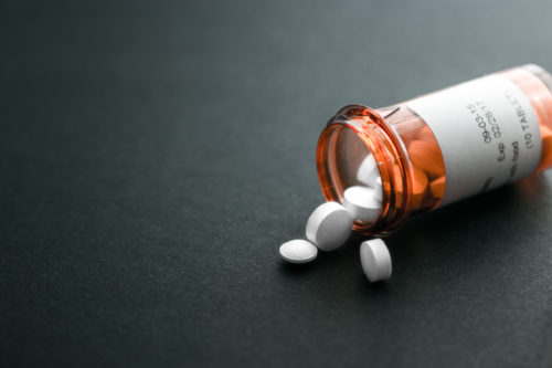 Pills spilling from a bottle onto a table
