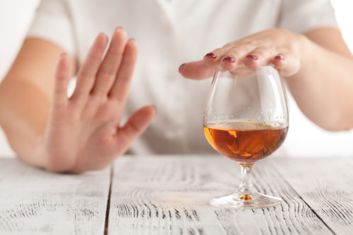 A woman unwinds with a glass of alcohol
