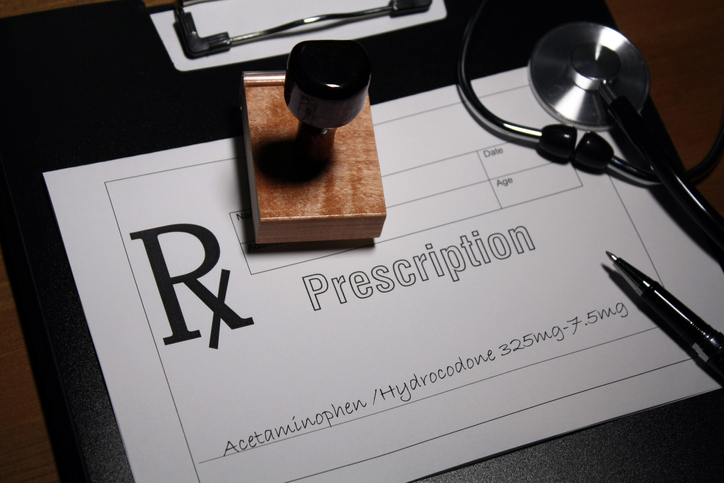 A doctor's prescription pad, with a written prescription for Acetaminophen/ Hydrocodone.