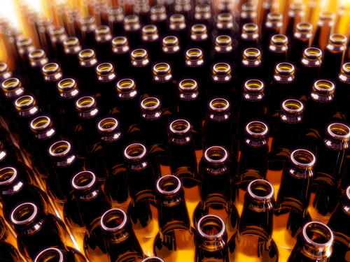A large group of open brown beer bottles.