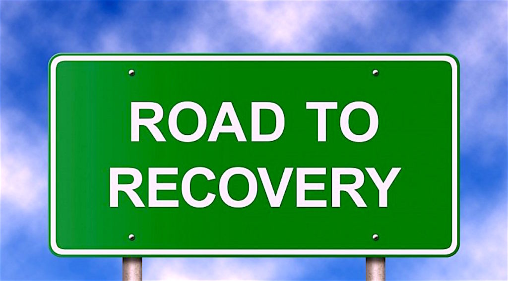 A graphic of a green road sign stating 'Road to recovery' on it.