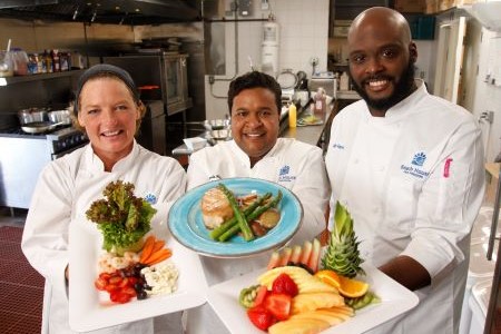 Three of the chefs at Beach House Recovery Center displaying the cuisine provided.