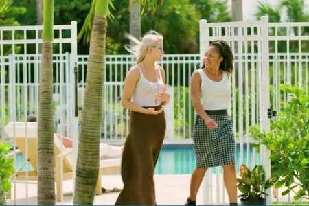 Two young women sharing a conversation while walking in the gardens at Beach House Recovery Center.