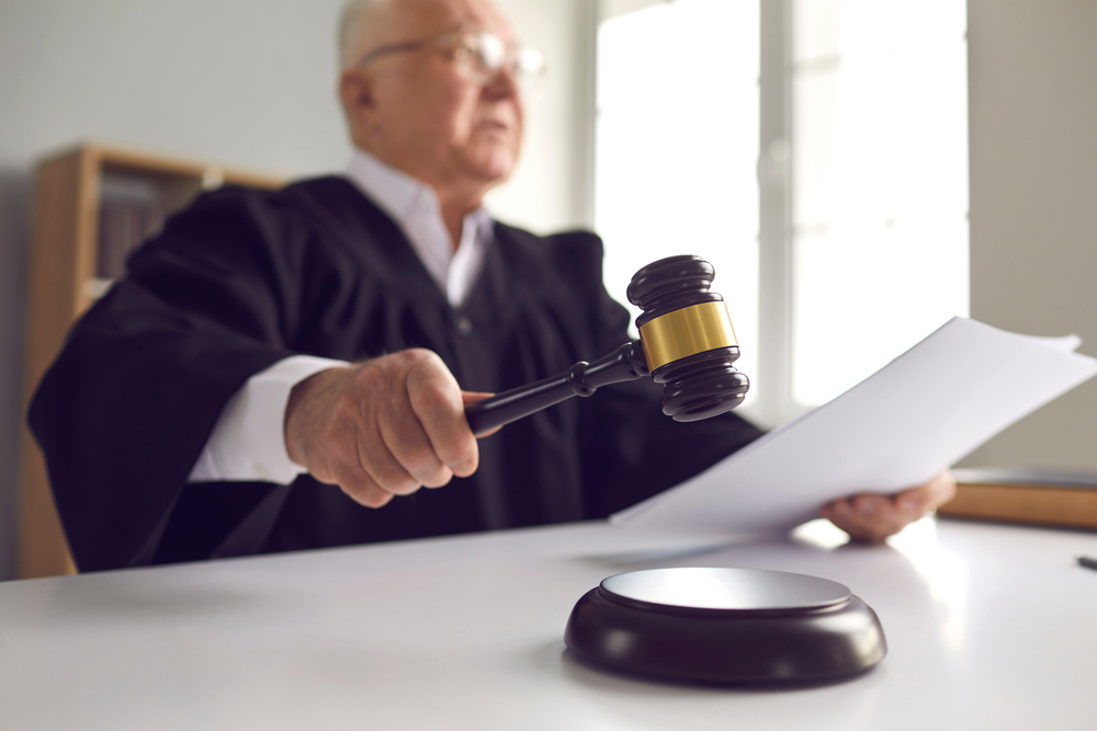 A close up of a judge slamming a gavel down.
