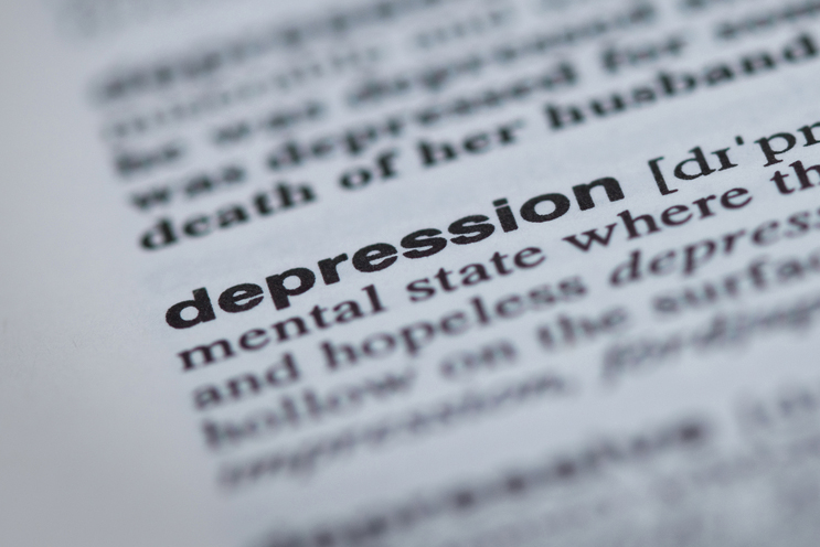 A close up of a dictionary with the definition for depression as the focus.