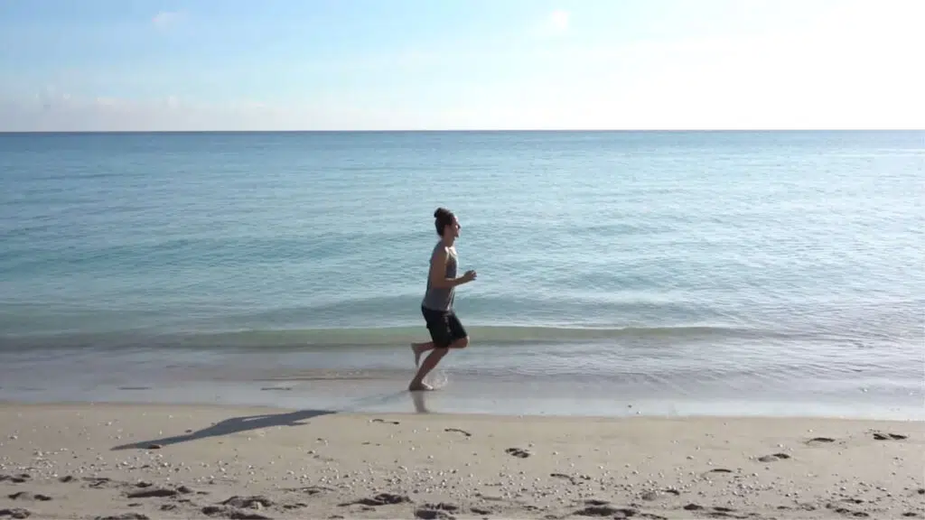 Man jogging along the beach by the ocean.