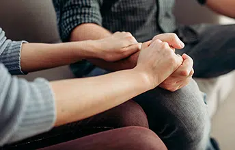 perople holding hands during therapy