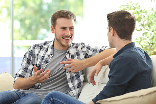 Two young men speaking on a couch
