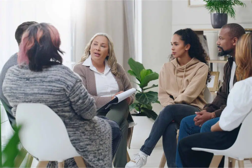 People sitting in a circle with a therapist