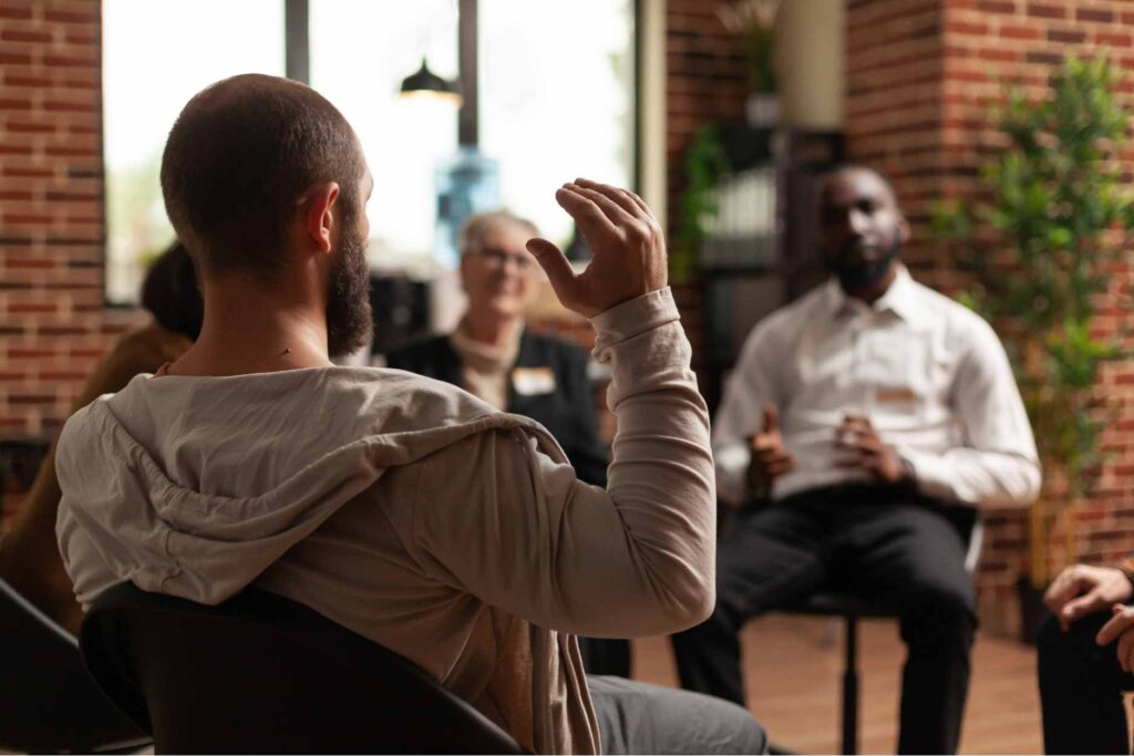 Man speaking to a group at therapy