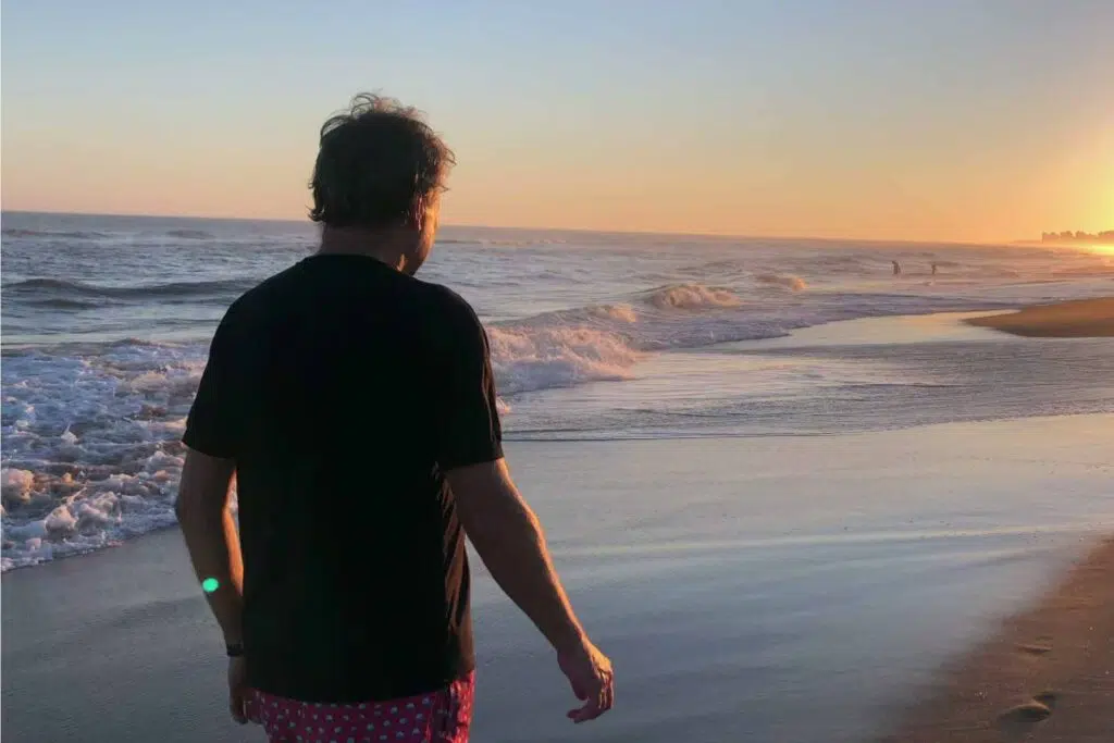 Man walking on a beach at sunset