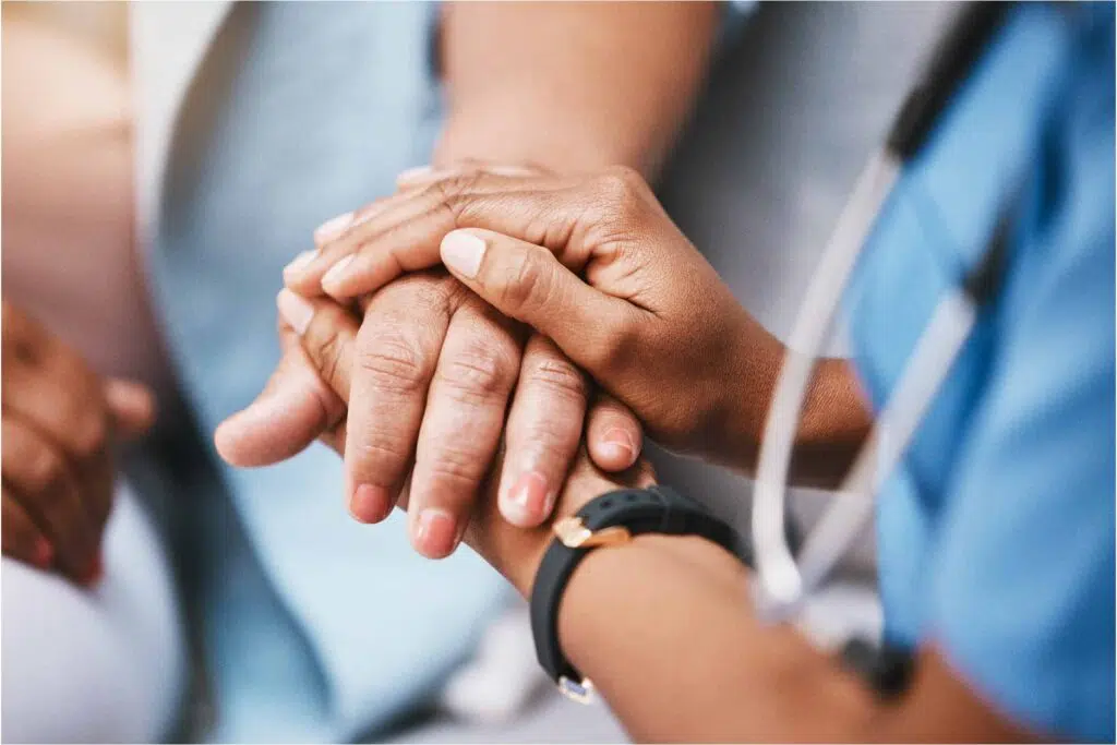 Close up of nurse holding a patients hand