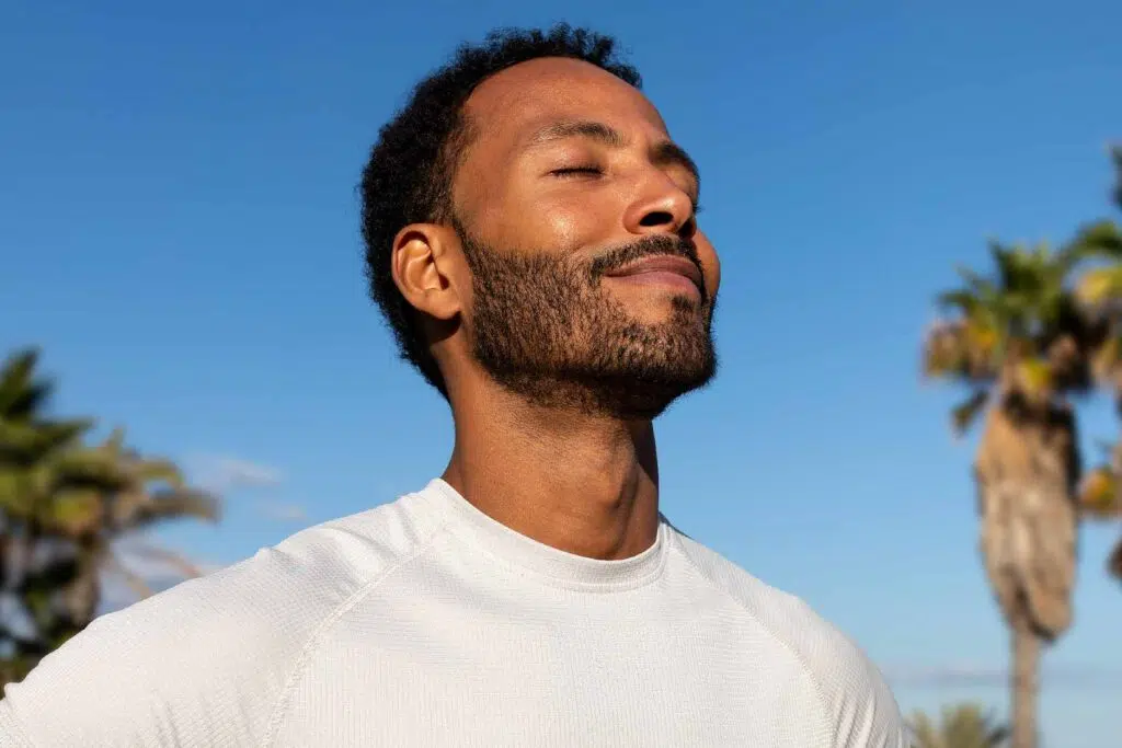 Close up of smiling man with eyes closed on a sunny day