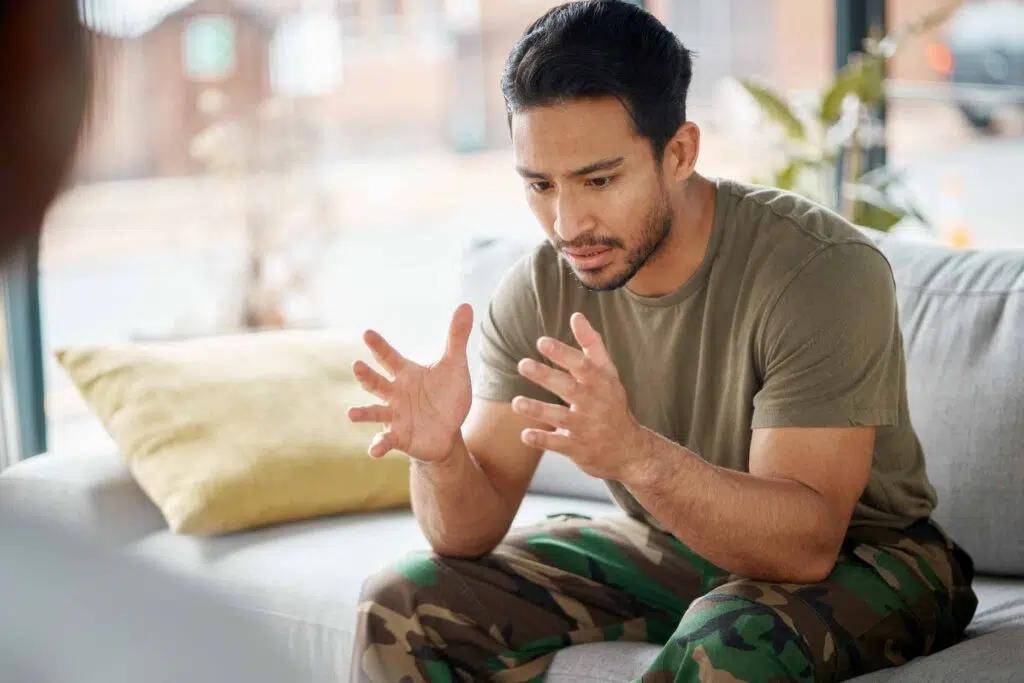 Man in military camo talking on a couch