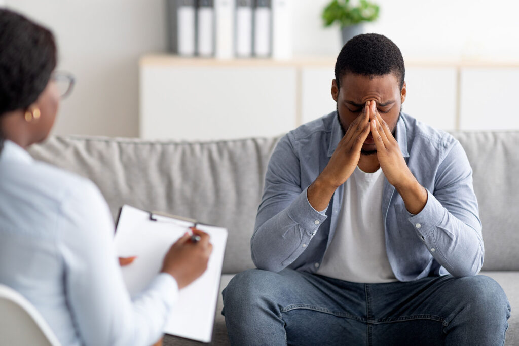 Man sitting on couch with therapist