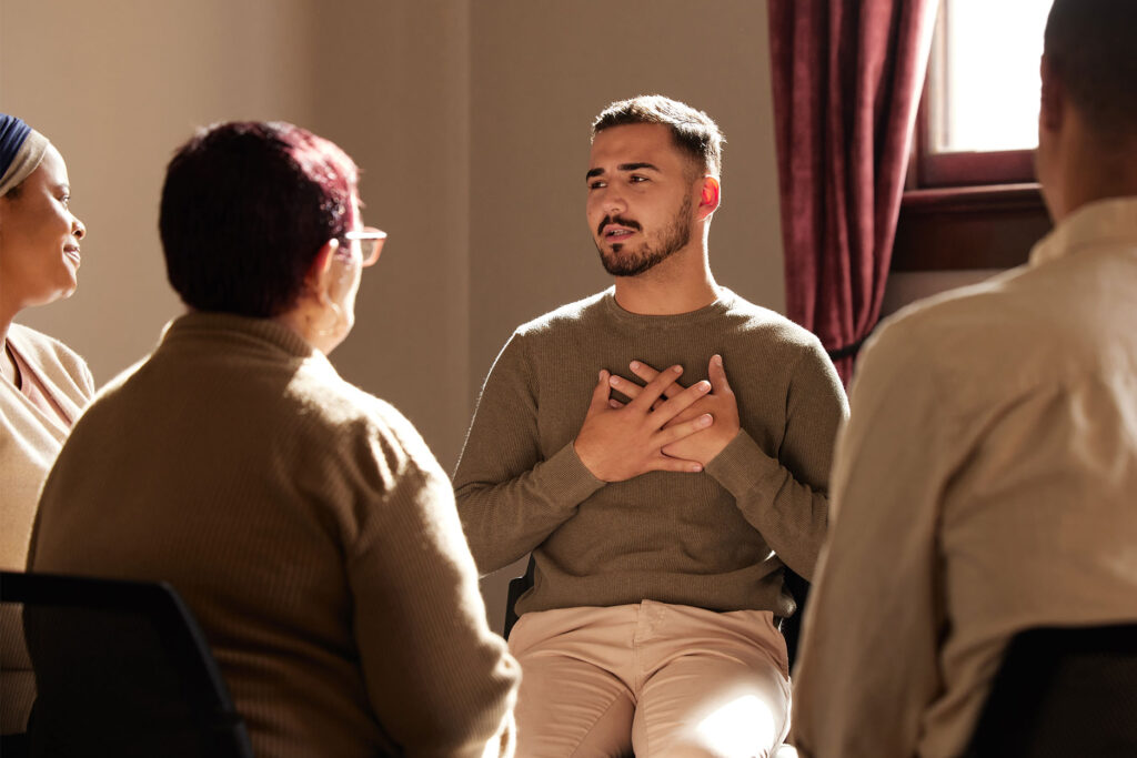 Man sitting with group in therapy