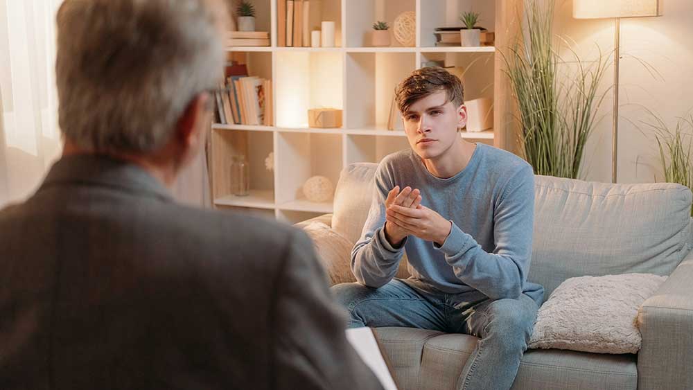 Young man sitting with therapist