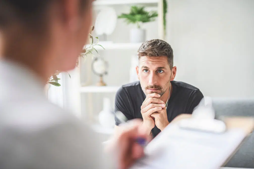 Man speaking with therapist on couch