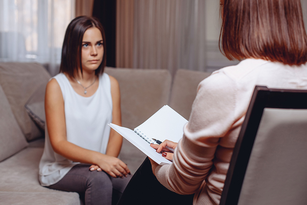 Young woman sitting with therapist