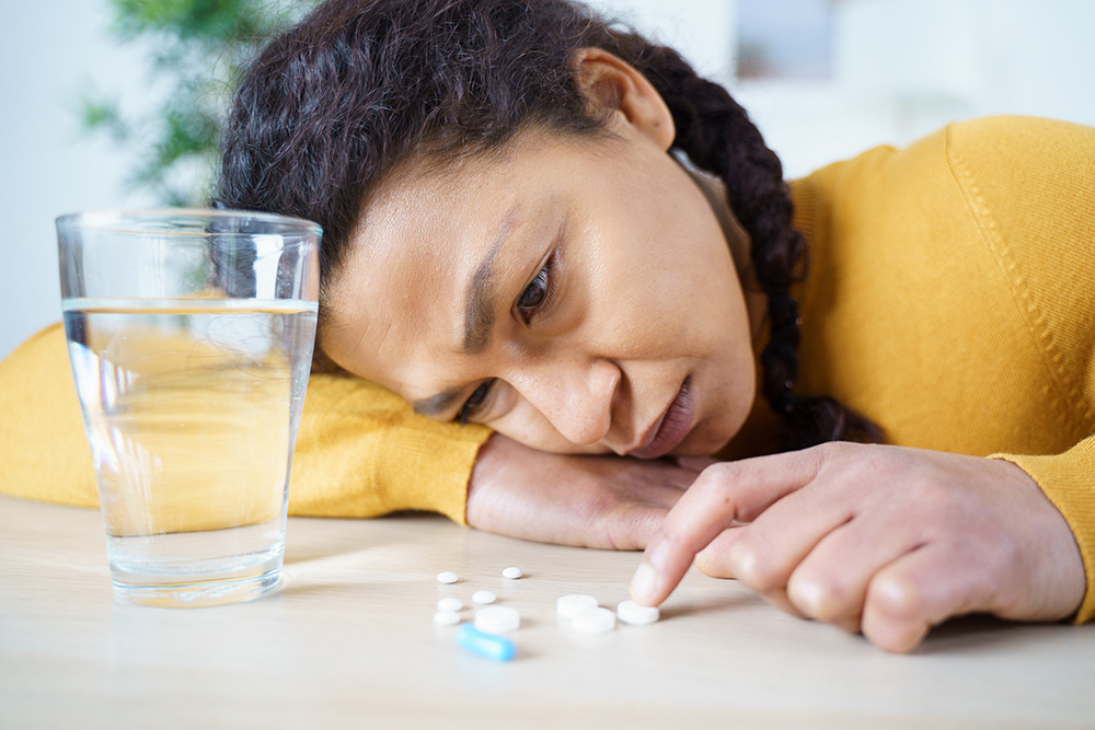Woman looking at pills on a table