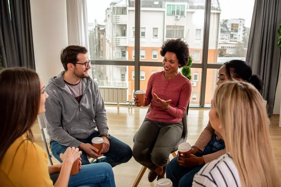 Smiling people in group therapy.